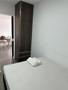 ein weißes Bett in einem Zimmer mit einem Tisch in der Unterkunft Apto aconchegante no Centro in Jaguarão