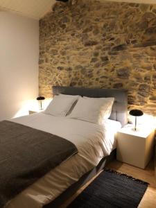 1 dormitorio con 1 cama grande y pared de piedra en Casa dos Veados, 