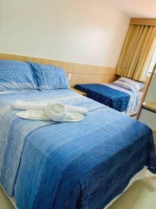 ein blaues Bett mit einem Handtuch darüber in der Unterkunft Casa Conforto Lençóis MA in Barreirinhas