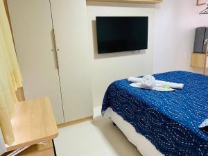 ein Schlafzimmer mit einem Bett und einem TV an der Wand in der Unterkunft Casa Conforto Lençóis MA in Barreirinhas