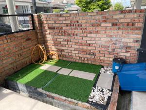 a brick wall with a artificial grassificialificialificialificialificialificialificialificialificial at Kuza Homes Batu Berendam in Melaka