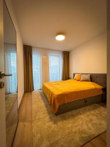 1 dormitorio con 1 cama grande con manta amarilla en Quiet Apartment with Garden and Free Parking, en Trnava