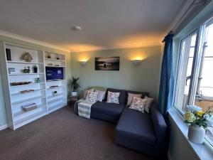 a living room with a couch and a window at Top Location Perranporth Apartment in Perranporth