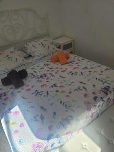 a bed with a flowery comforter with a stuffed animal on it at Piso para compartir in Santa Coloma de Gramanet