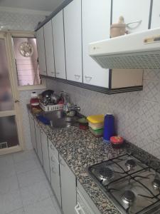 a kitchen counter with a sink and a stove at Piso para compartir in Santa Coloma de Gramanet