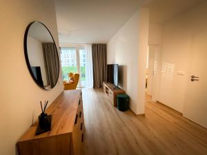 a living room with a mirror and a television at Quiet Apartment with Garden and Free Parking in Trnava