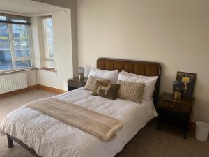 a bedroom with a large white bed with pillows at Harbour Views 3 Bed Townhouse with private off street parking and office in Portstewart