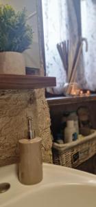 un lavandino in bagno con dispenser di sapone di casa medioevo a Viterbo