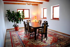 a dining room with a table and chairs on a rug at Hortensja in Iława