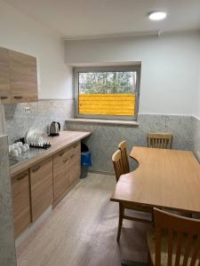 a kitchen with a wooden table and a window at Messe und Monteurzimmer Sehnde in Sehnde