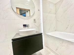 uma casa de banho com um lavatório e um espelho em Stylish 2BR Designer Flat Holland Park em Londres
