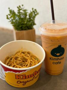 a cup of noodles and a drink on a table at Chubby 9 Room 7 in Bangkok