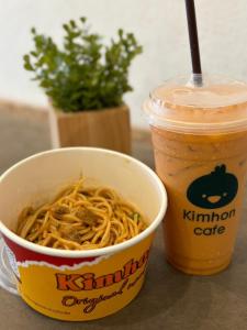 a cup of noodles and a drink on a table at Chubby 9 Room 7 in Ban Bang Phlat