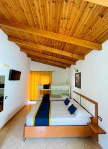 1 dormitorio con 1 cama con techo de madera en Vila Toskaj, en Vlorë