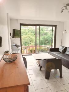 ein Wohnzimmer mit einem Sofa und einem Tisch in der Unterkunft Grands appartement à Ciboure in Ciboure