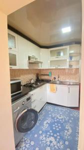 een keuken met een wastafel en een wasmachine bij Apartmen in Samarkand