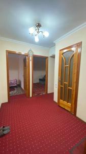 una habitación vacía con alfombra roja y puerta en Apartmen, en Samarkand