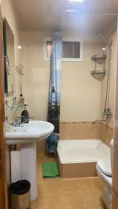 een badkamer met een wastafel, een bad en een toilet bij Apartmen in Samarkand