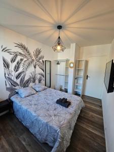 una camera da letto con un grande letto e un piumone blu di Charmant & spacieux 3 chambres - MM Apartment - Lyon Grand Parilly a Vénissieux