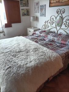 um quarto com uma cama grande e um cobertor branco em Homesweethome em Tempio Pausania