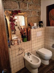 uma casa de banho com um lavatório, um WC e um espelho. em Homesweethome em Tempio Pausania