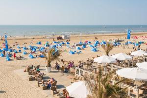 a beach with a lot of people and the ocean at Pension Sixtysix in Zandvoort