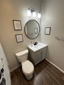 a bathroom with a toilet and a sink and a mirror at Family Friendly Fun Dogtown Cottage Near The Zoo in Benton
