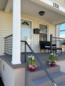 uma casa com dois vasos de plantas no alpendre da frente em Family Friendly Fun Dogtown Cottage Near The Zoo em Benton