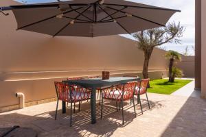 a table and chairs under an umbrella on a patio at Villa Saadia in Douar Bellouk