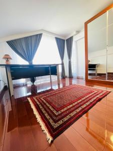een kamer met een tapijt op een houten vloer en een piano bij SOHO Pristina Kosovo in Pristina