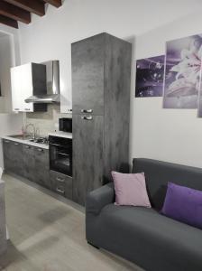 a living room with a couch and a kitchen at Aretusa Apartments in Siracusa
