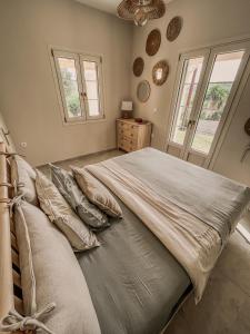 a bedroom with a large bed and two windows at Villa Elia in Peroulades