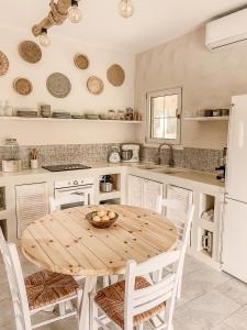 a kitchen with a wooden table and white appliances at Villa Elia in Peroulades