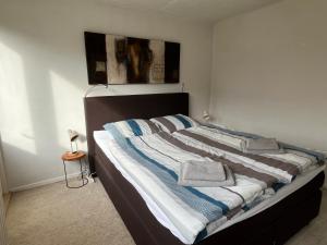 a large bed with towels on it in a bedroom at Beach House Wantveld Noordwijk aan Zee in Noordwijk aan Zee