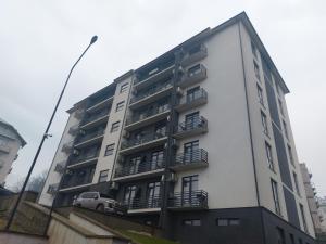 un edificio blanco con balcones y un coche en él en Aqua Apart Polyana, en Polyana