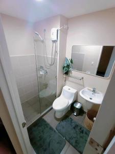 a bathroom with a shower and a toilet and a sink at Cozy Studio Unit, Avida Towers Aspira in Cagayan de Oro