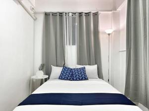 15 Secs to Beach-2BR w/ Kitchen & Newly Renovated في بوراكاي: غرفة نوم بسرير ومخدة زرقاء وبيضاء