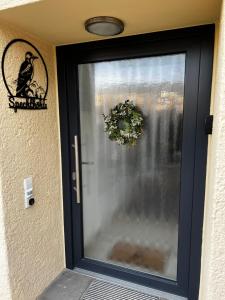 eine schwarze Tür mit einem Fenster mit einem Vogel drauf in der Unterkunft Spechthöhle - St. Georgen in Sankt Georgen im Schwarzwald