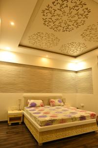 a bedroom with a bed with a flowery ceiling at SHREE VILLA in Jaipur