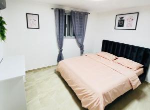 1 dormitorio con 1 cama con almohadas rosas en אחוזת נווה גד en Telamim