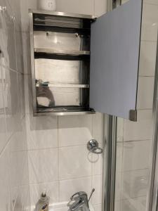 W łazience znajduje się lustro, umywalka i prysznic. w obiekcie Gloucester Road Studio w Londynie