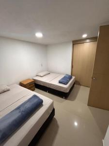 a bedroom with two beds and a door to a closet at Habitación Familiar En Sabaneta in Sabaneta