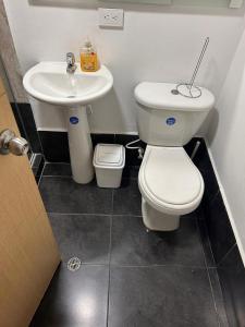 a bathroom with a toilet and a sink at Habitación Familiar En Sabaneta in Sabaneta