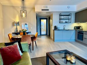 ein Wohnzimmer und eine Küche mit einem Sofa und einem Tisch in der Unterkunft An elegant and exclusive apartment in Bjørvika Oslo in Oslo