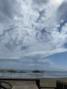 tres sombrillas en la playa bajo un cielo nublado en Nature view, walking distance to the beach, en Özdere