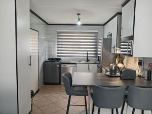 a kitchen with a table and chairs in a kitchen at Maneli 69 in Boksburg