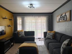 a living room with two couches and a window at Maneli 69 in Boksburg