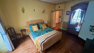 1 dormitorio con 1 cama con mantas y almohadas azules en CHAMBRES D'HÖTES DANS MAISON DE MAÏTRE DU XVIIIe SIECLE, en Houdan