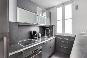 uma cozinha com utensílios de aço inoxidável e um lavatório em UNESCO-SUFFREN em Paris