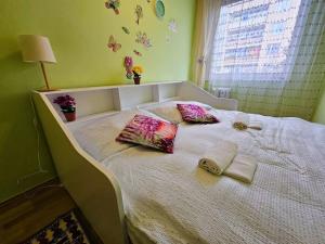 a bed with two pillows on it with a window at Sunny & Spacious, 10mins to Centre, Free parking, Quiet location, New Furniture, Balcony in Prague